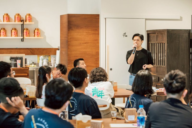 嘉義在地青年創業代表張延齊（站立者）與在座青年代表分享「返嘉創業」歷程，並鼓勵青年帶著熱情回鄉圓夢。