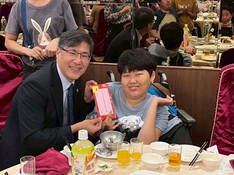 摸彩活動中，高醫大董事長陳建志為幸運得獎的孩童獻上紅包。(記者陳雯萍攝)