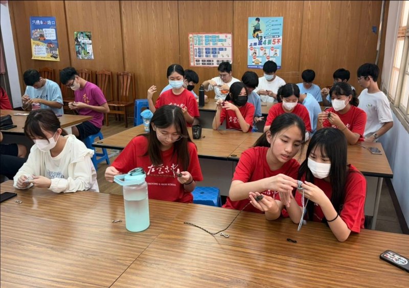 學生們細心操作，用半結連織的手法將傘繩變化為撇纜繩球。傘繩可反覆拆解再利用，不僅能做成鑰匙圈或吊飾，更兼具環保與時尚。（左營高中提供）