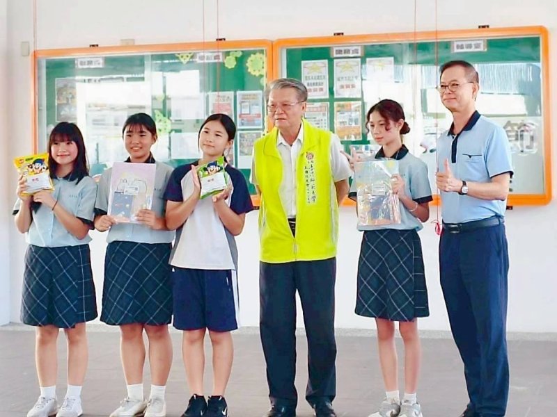 前教育局長王進焱（左4)頒發獎品給學生。右一為校長黃火炎。（旗津國中提供）