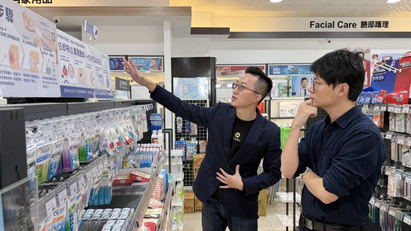 意恩醫研負責人趙育賢（左）向青年局長林楷軒（右）解說，如何引導民眾操作「HooLi空中護理站」智慧櫃位快速配對合適的傷口照護方案。