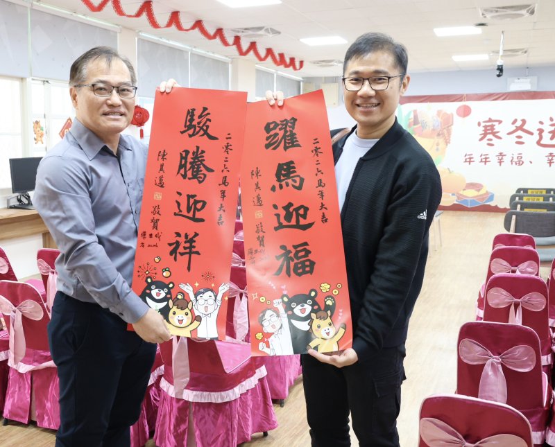 蔡典成老師（左）現場揮毫寫春聯。