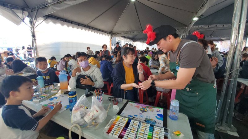 冬日遊樂園寫生首日，教育局長吳立森協同副局長劉靜文、社教科長李靖葦、新上國小校長王彥嵓發送超人力霸王小禮物，親子爭相索取，現場熱鬧滾滾。（漾新聞記者陳雯萍攝）