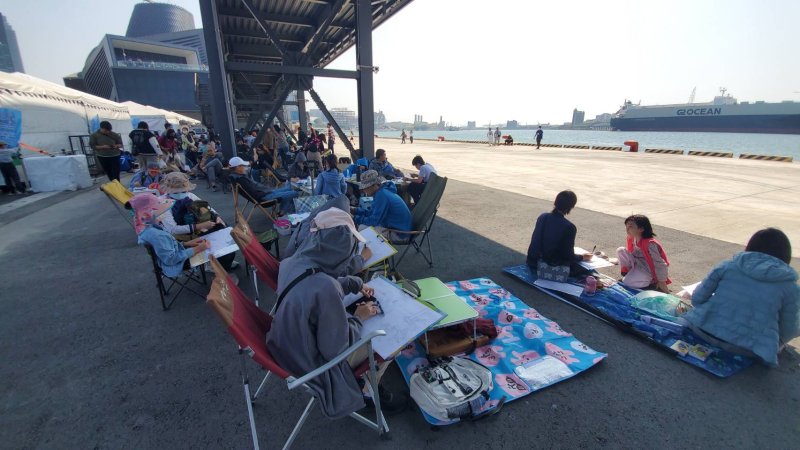 冬日遊樂園寫生首日，教育局長吳立森協同副局長劉靜文、社教科長李靖葦、新上國小校長王彥嵓發送超人力霸王小禮物，親子爭相索取，現場熱鬧滾滾。（漾新聞記者陳雯萍攝）