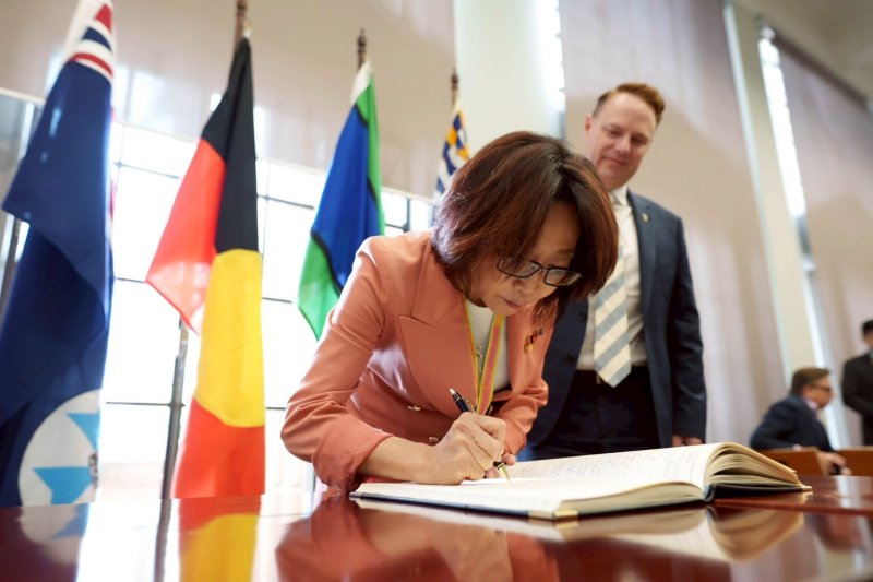 議長康裕成在布里斯本市政廳的簽名簿上簽名留念。