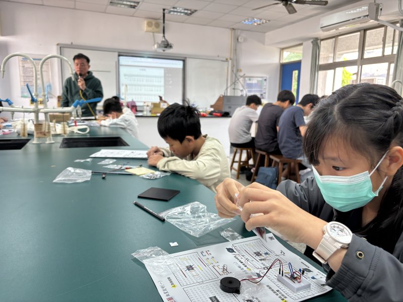 陳坤龍老師指導學生利用特殊IC搭配蜂鳴器組裝與石墨導電的特性製作會唱歌的鉛筆。 陳坤龍老師指導學生利用特殊IC搭配蜂鳴器組裝與石墨導電的特性製作會唱歌的鉛筆。