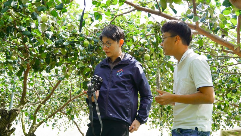 青年局長林楷軒(左)前往燕巢「靜園農場」實地參訪伊凌科技智慧農機實證落地的蜜棗園,並與執行長許潪銘(右)交流如何透過自動化設備解決果園缺工問題。 青年局長林楷軒(左)前往燕巢「靜園農場」實地參訪伊凌科技智慧農機實證落地的蜜棗園,並與執行長許潪銘(右)交流如何透過自動化設備解決果園缺工問題。