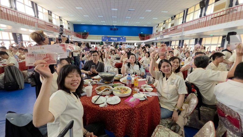 許多校友拿到自己的生日百元鈔時，忍不住反覆確認鈔票上的數字，當場拍照留念。對於這些有錢也買不到的「專屬生日百元鈔」，不少人為他的用心感動，當場落淚，更多人說，「我要裱起來當傳家寶」。（漾新聞記者陳雯萍攝）