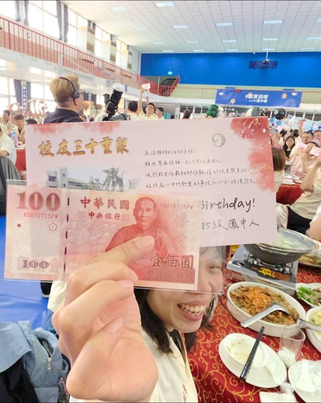 黃照智更獻上精心設計的「專屬生日百元鈔」給校友，這是他特別從流通的百元鈔中，找到當年同學們的學號，從67(年)開始，接著是幾班幾號，除了英文，六個數字完全一模一樣，讓拿到的校友，都感動不已！(漾新聞記者陳雯萍攝)