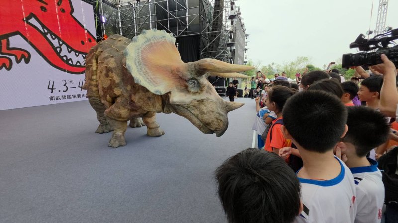 高雄市衛武營有恐龍，而且還是「會動的恐龍」，高雄兒童節，吳立森帶領學童與擬真恐龍同歡。(漾新聞記者陳雯萍攝)