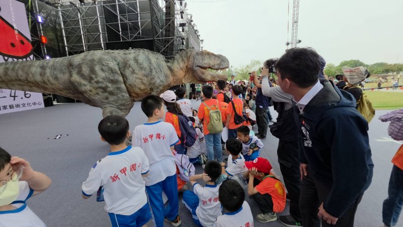 高雄市衛武營有恐龍，而且還是「會動的恐龍」，高雄兒童節，吳立森帶領學童與擬真恐龍同歡。(漾新聞記者陳雯萍攝)