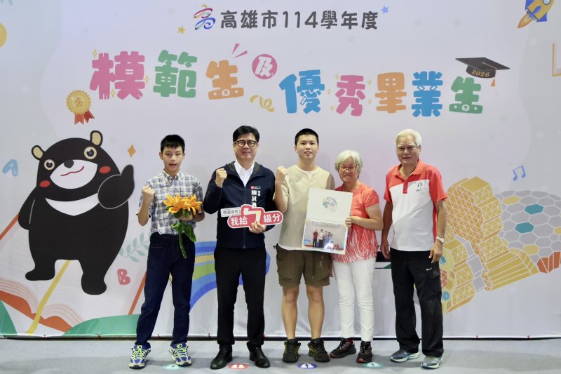 獲得市長獎的光華國中畢業生吳孟樵（右三）今天也在家人陪同下，特別跨區與陳其邁市長合影；他興奮的拿著就讀五權國小時獲得市長獎，曾經與陳其邁市長合影的照片入鏡。