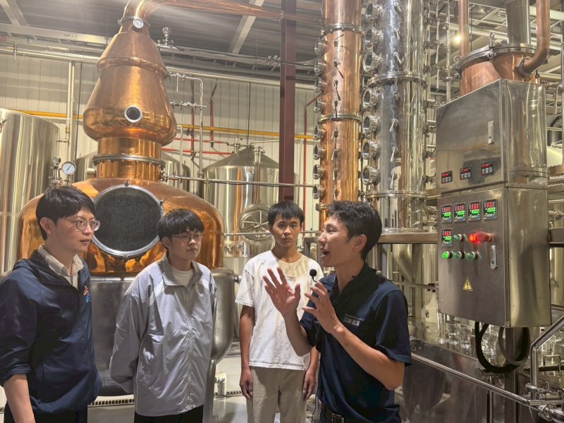 亞耕酒業廠長趙耕毅（右一）向青年局長林楷軒（左一）及實習生樹德科技大學黃宏佑（左二）與正修科技大學劉青叡（右二）解說酒類釀造流程及設備運作，分享釀酒產業的專業技術與職人精神。