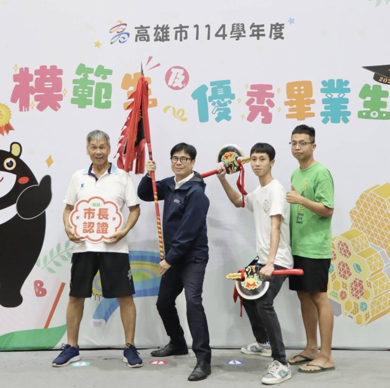岡山農工模範生暨市長獎畢業生何宇祐(右二)今天與阿公郭文賓(左一)、弟弟帶著象徵家族精神的宋江陣頭旗與雙斧,與市長陳其邁一同合影,成為現場最吸睛的畫面。 岡山農工模範生暨市長獎畢業生何宇祐(右二)今天與阿公郭文賓(左一)、弟弟帶著象徵家族精神的宋江陣頭旗與雙斧,與市長陳其邁一同合影,成為現場最吸睛的畫面。