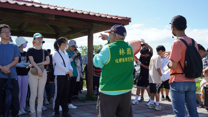 林園當地保育學會的導覽老師向青年志工簡介紅樹林生態，幫助志工更理解淨灘行動對自然生態的重要性。