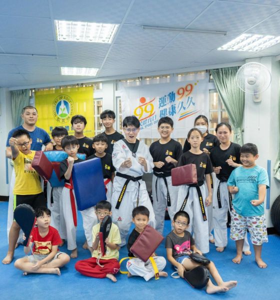  青年局長林楷軒(中)與館內學員一同體驗跆拳道防身課程，活動後與小學員們開心合影。