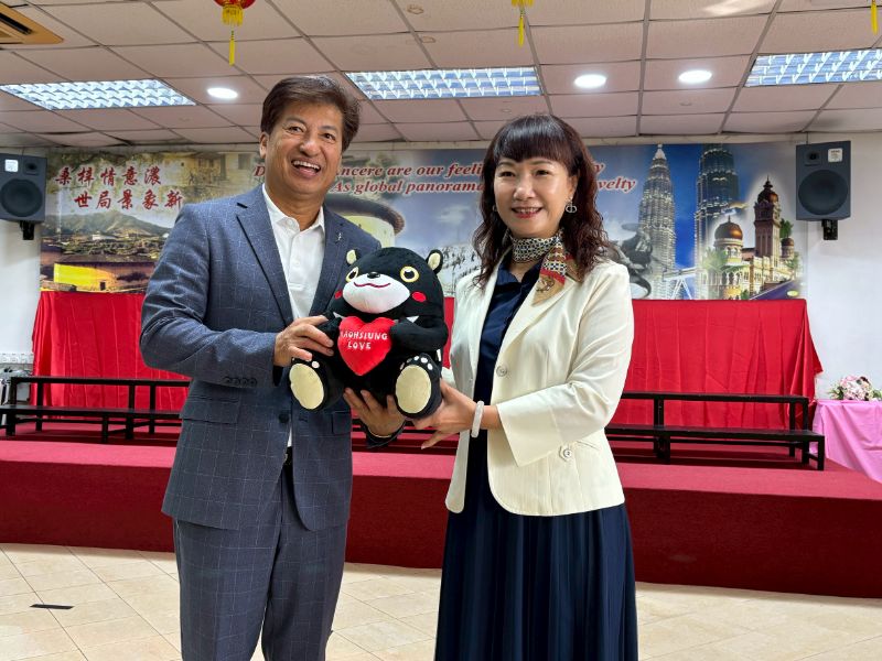 高市客委會主委楊瑞霞（右）代表高雄市長陳其邁致贈吉祥物高雄熊給檳城客家公會會長高級拿督彭永添（左）