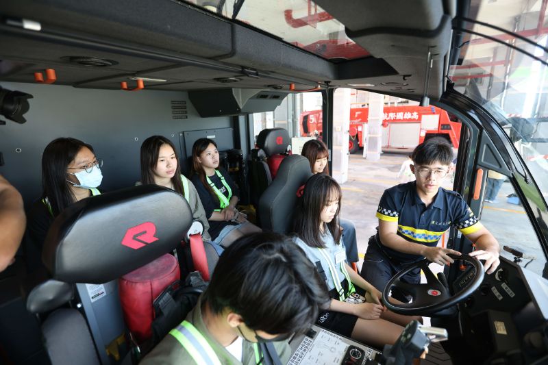 學員在消防車聆聽機場消防人員講解緊急應變任務，了解機場消防隊的重要及安全性。