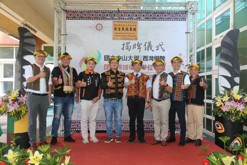 國立中山大學西灣學院「國際跨域學士學位學程原住民族專班」揭牌，左起中山大學國際跨域原民專班主任許家豪、高雄市政府原民會機要秘書瑪紹‧昂艾、立委伍麗華屏東服務處副主任黃敬庭、教育部主任秘書林伯樵、中山大學校長李志鵬、副校長郭志文、西灣學院院長王宏仁、原民台南部分台主任宋茂璋。