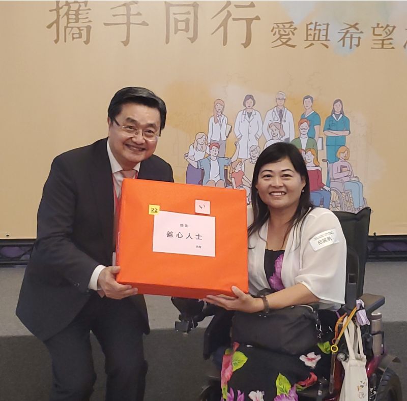 創會理事長鐘育志醫師頒發摸彩品予病友邱麗夙。(記者陳雯萍攝)