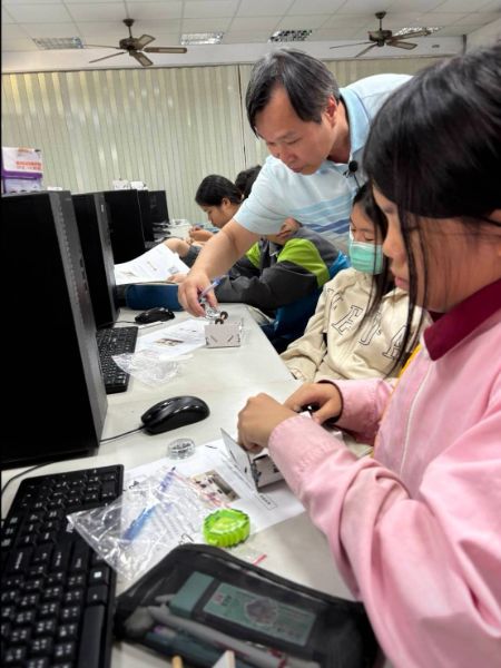 許國忠老師指導學生利用磁鐵的磁性與地心引力的相互關係製作懸浮在半空中的磁浮筆。 許國忠老師指導學生利用磁鐵的磁性與地心引力的相互關係製作懸浮在半空中的磁浮筆。