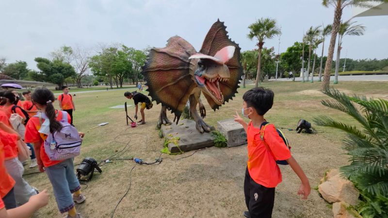鳳山區忠孝國小學童在記者會中，近距離與恐龍互動，超新體驗。(漾新聞記陳雯萍攝)